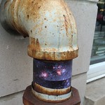 M74 Spiral Galaxy wrapped around water pipe outside The Book Cellar bookstore