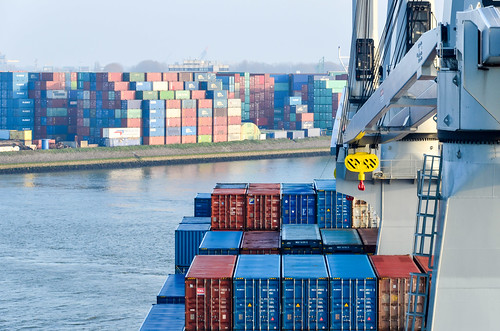Navigating between containers with a cargo ship in the port of Rotterdam