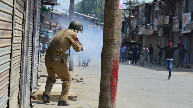 Protesting youth dares police men to fire tear gas shell aiming directly at him.
