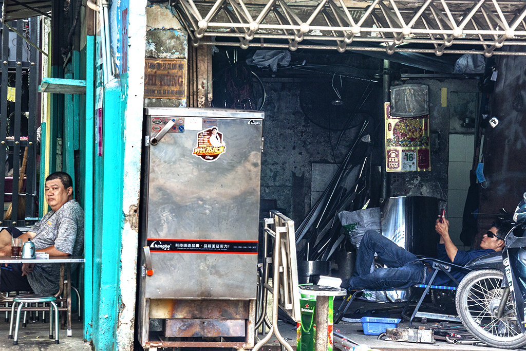 Man at cafe and man in repair shop on Hau Giang Street--Saigon
