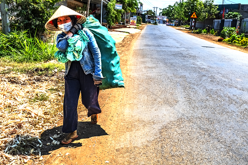 Woman carrying heavy load in scorching heat--Ea Kly