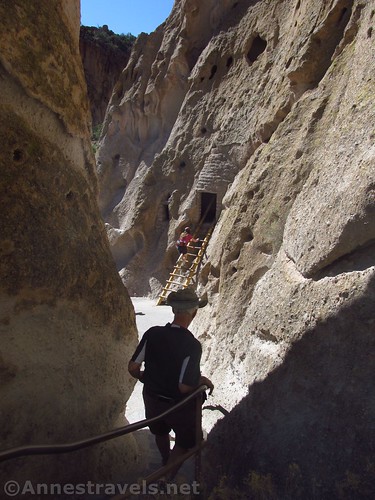 Descending through a narrow spot to the third cave along the Main Loop in Bandelier National Monument, New Mexico
