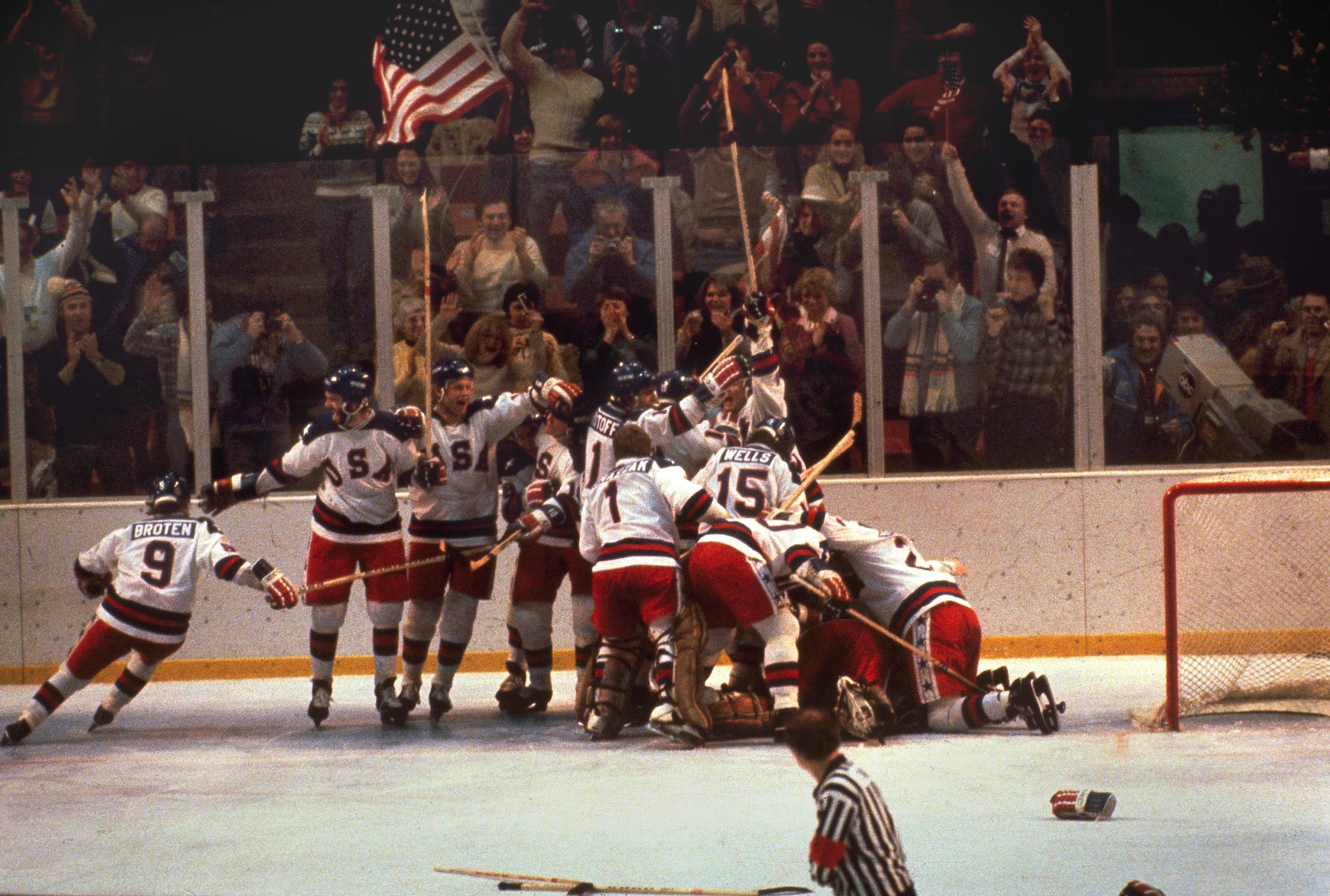 The U.S. hockey team pounces on goalie Jim Craig after a 4-3 victory against the Soviets in the 1980 Olympics, as a flag waves from the partisan Lake Placid, N.Y. crowd, February 22, 1980. (AP Photo)