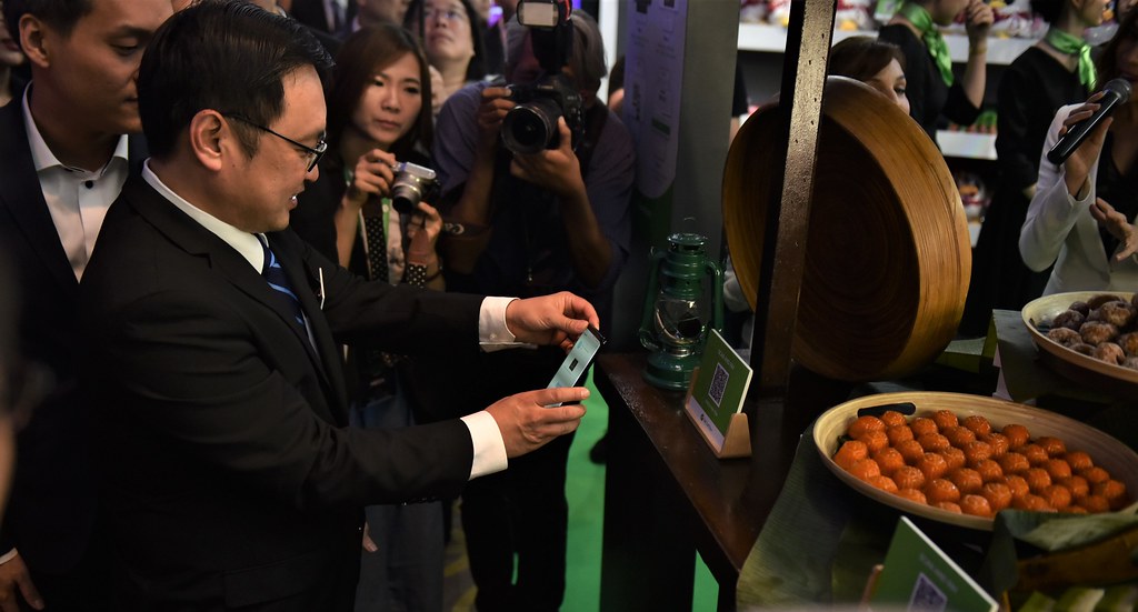 YB Tuan Chong Chieng Jen, Deputy Minister of Domestic Trade and Consumer Affairs, trying out the conceptualised payment method at street store in the Experience Zone.