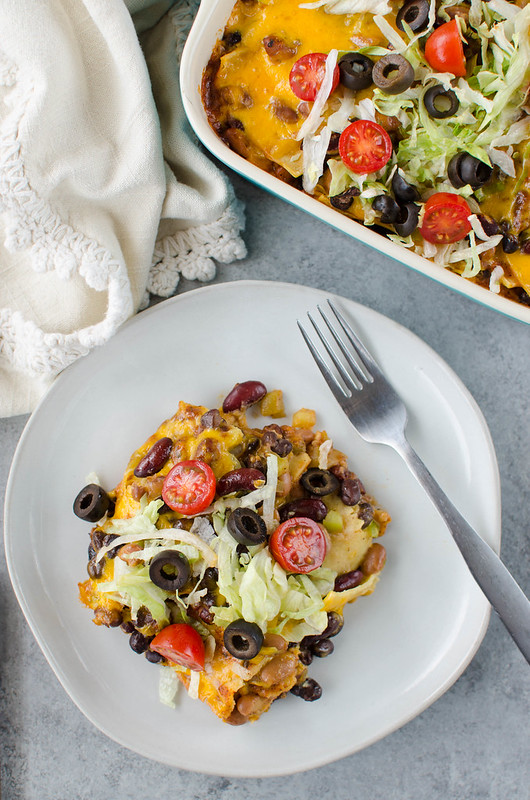 Three Bean Enchilada Casserole - black beans, pinto beans, and kidney beans layered with corn tortillas, enchilada sauce, and cheese. An easy meatless meal the whole family will love! 
