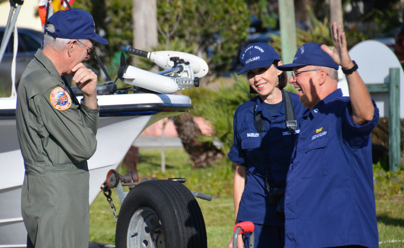 Members of the U.S. Coast Guard Auxiliary including an AUXAIR pilot (left) and a Coast Guard Auxiliary photographer (center) at a community boating safety event.