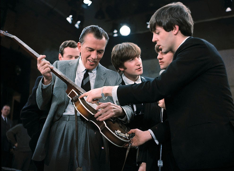 Ed Sullivan examine's Paul McCartney's bass guitar prior to a show in February 1964.