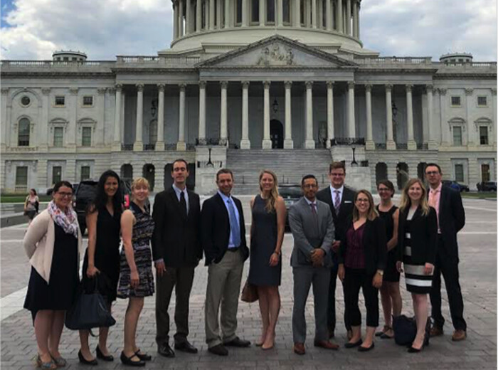 A group of people in formal wear stand outside the U.S. Capitol building.