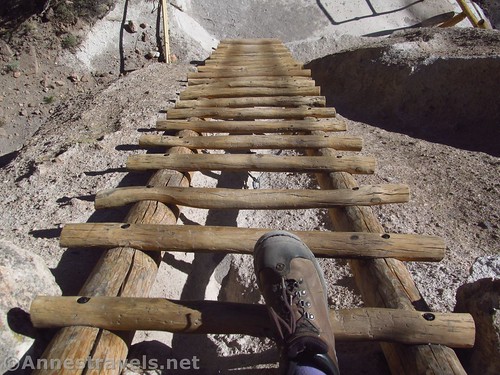 Preparing to descend to one of the ladders from Alcove House in Bandelier National Monument, New Mexico