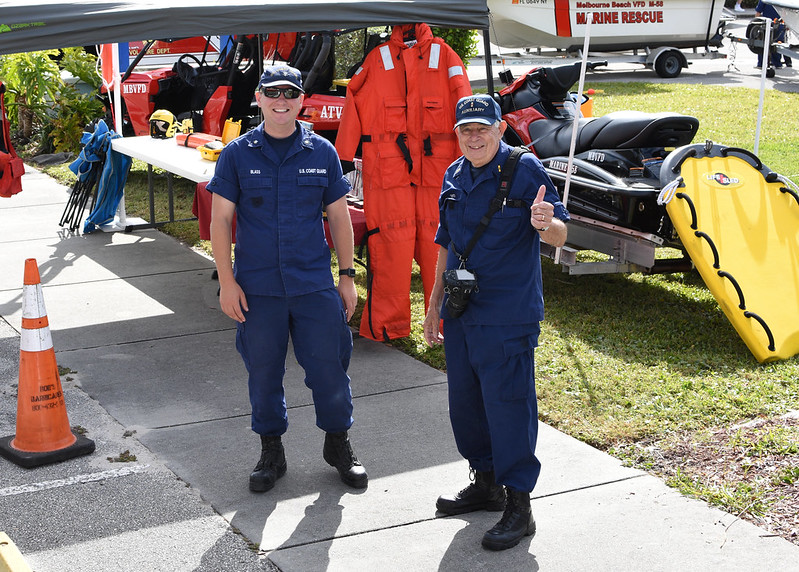 An active duty U.S. Coast Guard member (left) and a Coast Guard Auxiliary photographer (right) pose for a photo at a community boating safety event.