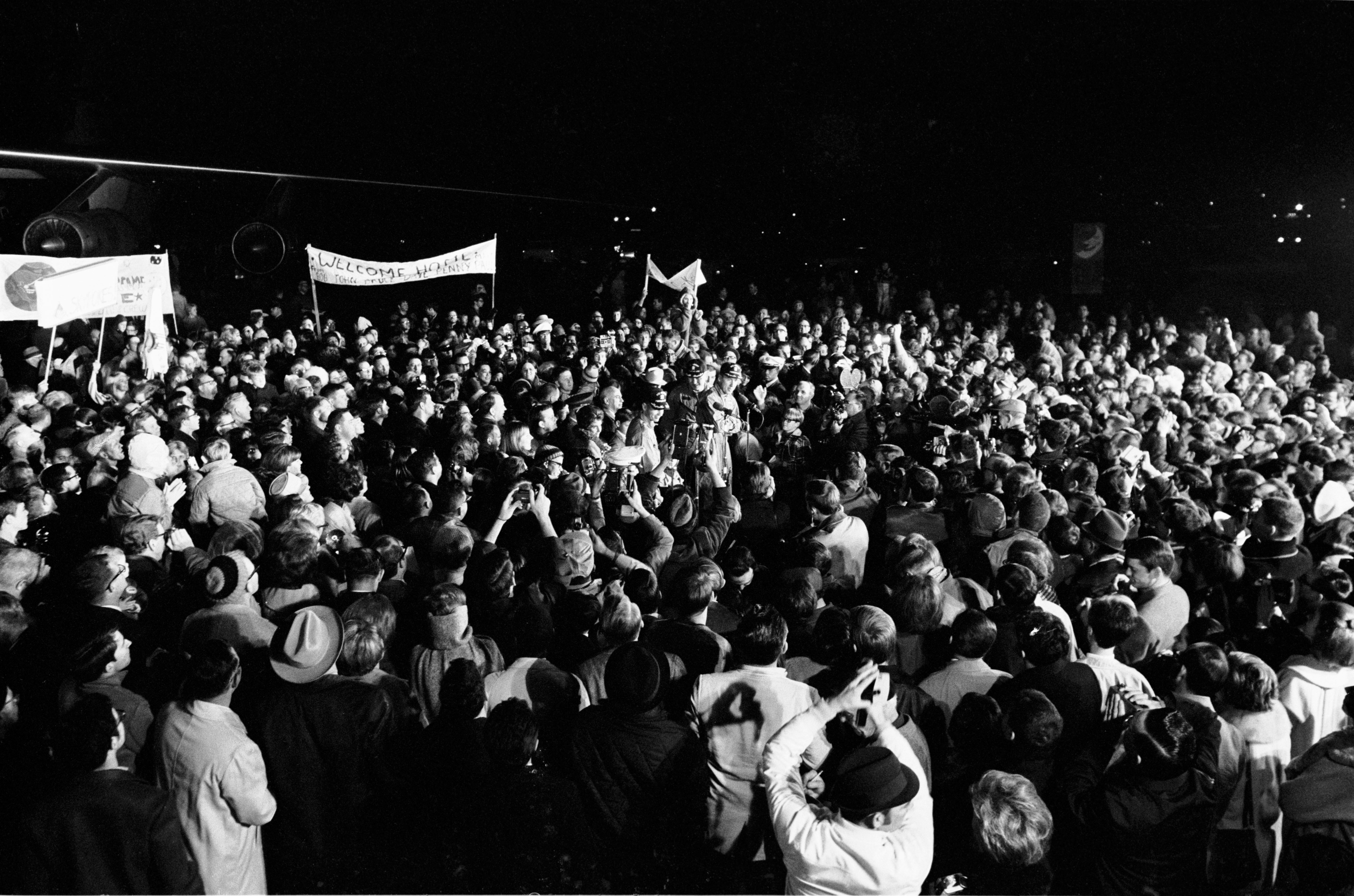 Although it was past 2 a.m., a crew of more than 2,000 people were on hand at Ellington Air Force Base to welcome the members of the Apollo 8 crew back home. Astronauts Frank Borman, James A. Lovell Jr., and William A. Anders had just flown to Houston from the pacific recovery area by way of Hawaii. The three crewmen of the historic Apollo 8 lunar orbit mission are standing at the microphones in center of picture. Photo Number: S69-16402 Date: December 29, 1968 