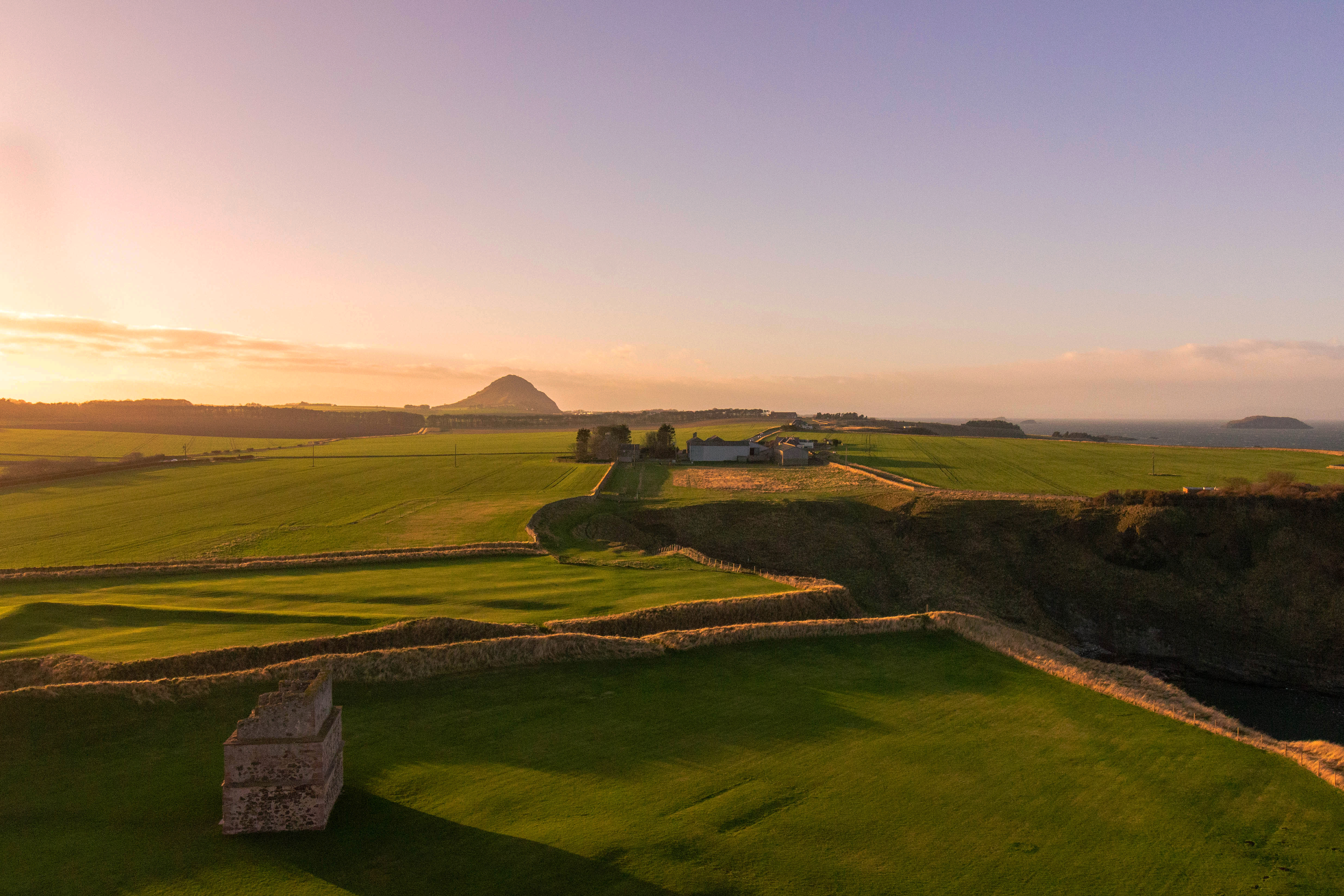 View towards North Berwick Law from Tantallon Castle at golden hour
